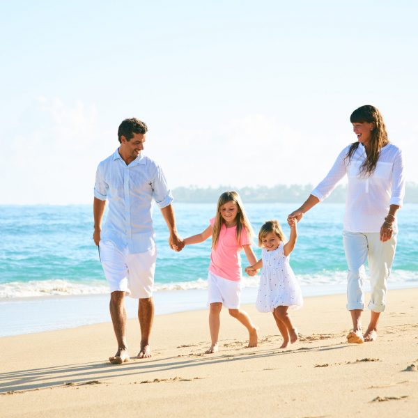 Happy family enjoying walk on the beach