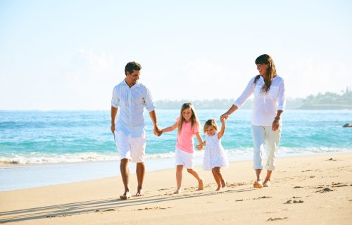 Happy family enjoying walk on the beach